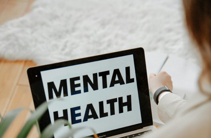 Person using laptop displaying mental health message for awareness and emotional wellness